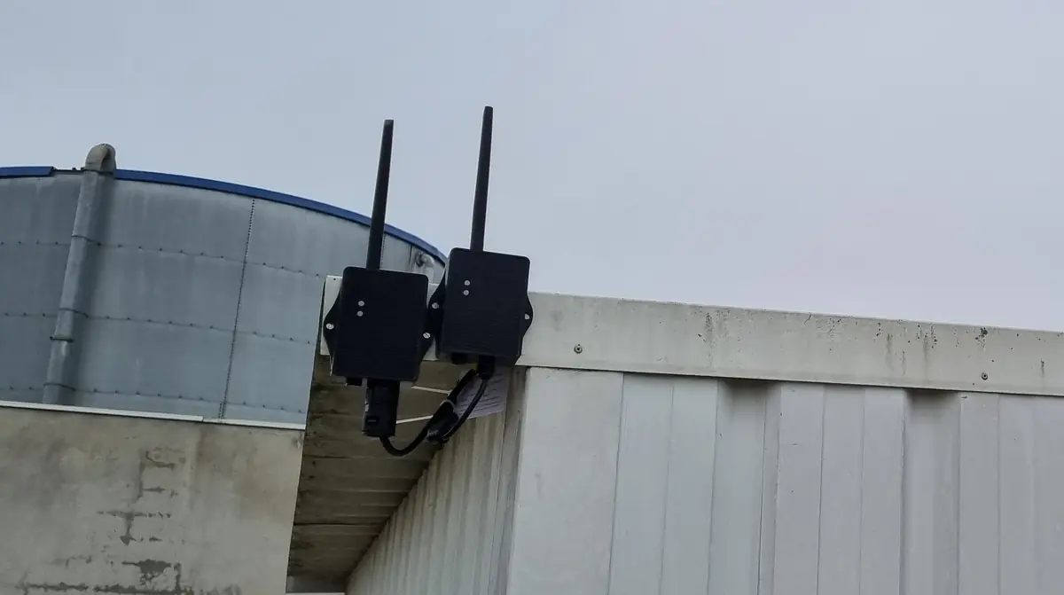 Un capteur de niveau Dragino PS-CS-I et un transmetteur de qualité de l'eau WQS-CS installés en extérieur, en haut d'un bâtiment technique, pour recharger leur batterie