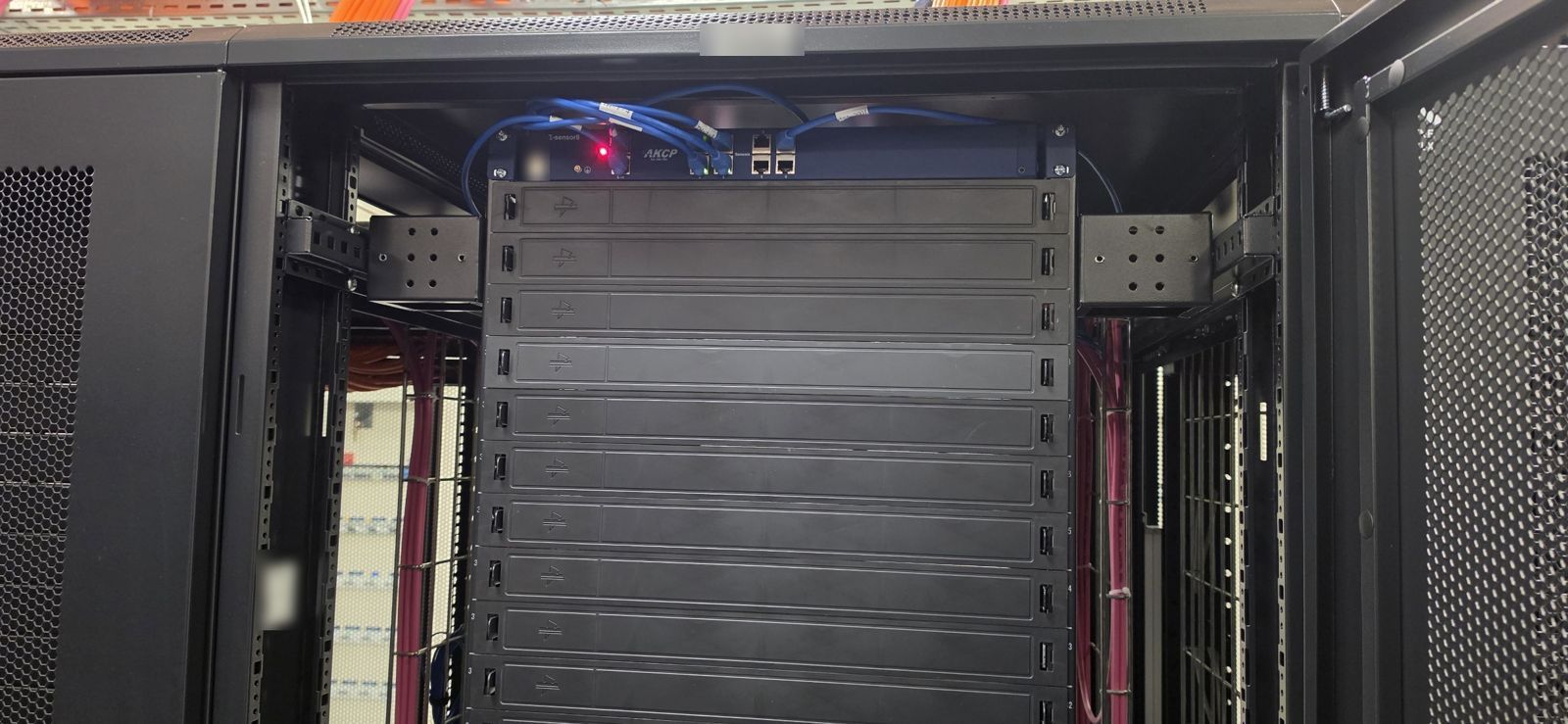 Unité d’extension AKCP E-Sensor8 montée en haut de baie dans la salle 1, avec ses capteurs raccordés